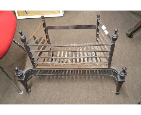 A cast iron fire grate in the Georgian Neoclassical style with a pierced front grill and finial decoration, 74cm wide