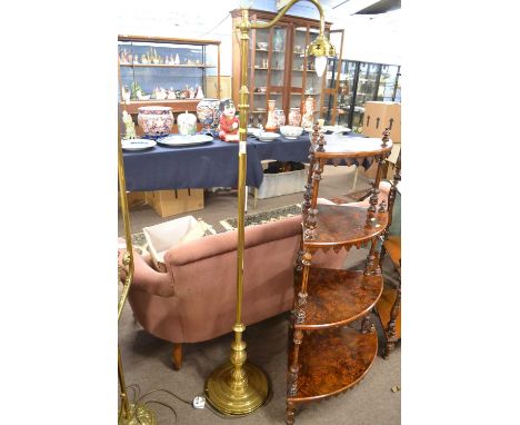 An early 20th Century brass standard lamp fitted with a scrolled arm, plain stem and a stepped circular base and tinted glass