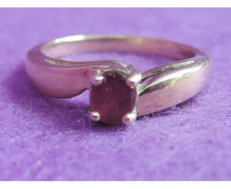 A lady's dress ring having a ruby solitaire to raised crossover shoulders on a 9ct gold loop,  size N