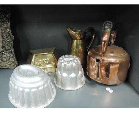 A selection of kitchenalia including jelly moulds, copper kettle, brass tea caddy and jug 