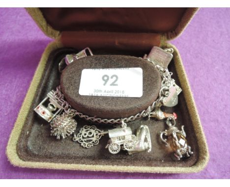 An HM silver double link charm bracelet with padlock clasp and 11 charms (5 loose)