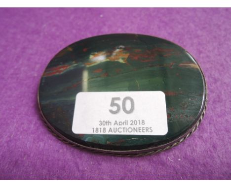 An oversized oval bloodstone brooch having a white metal mount with twist decoration, missing pin, no marks tested as silver