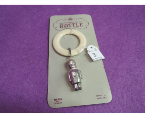 A silver rattle modelled as a soldier with white plastic teething ring, still attached to retail card,  Chester 1959, Wilmot 