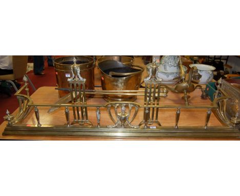 An early 20th century brass fender together with a  set of turned brass fire tools and andirons