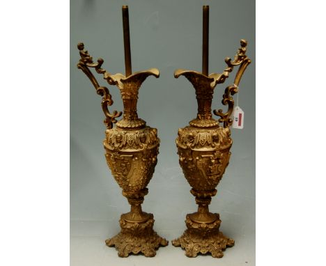 A pair of early 20th century gilt metal lamp bases in the form of a classical ewer