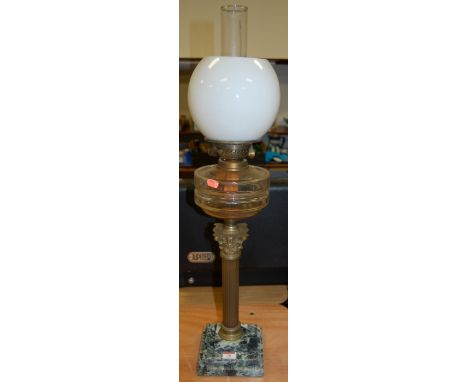 An early 20th century brass corinthian column oil lamp having an opalescent glass shade, clear glass reservoir, on a stepped 