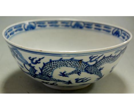 A Chinese export blue & white bowl decorated with dragons chasing a pearl, four character mark verso, 20cm diameter Condition