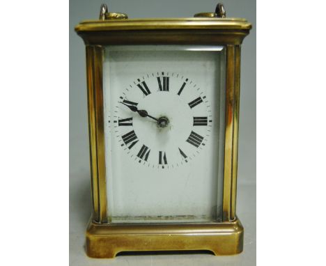 An early 20th century lacquered brass cased carriage clock, having white enamel dial with Roman numerals and platform lever e