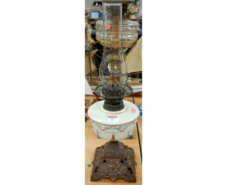 A late 19th century oil lamp having a glass reservoir and cast iron base