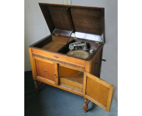 A cabinet gramophone, a Gilbert console model in oak case, with bugle tone-arm and Tone Reflector soundbox, supplied by Bruce