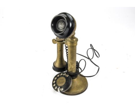A telephone, a brass candlestick type (no markings), with black dial and modern wires 