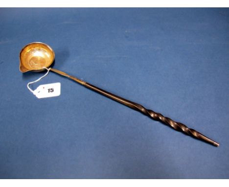 A Georgian Toddy Ladle, the bowl with side spout, inset coin dated 1708 and twisted handle, 36.5cms long.