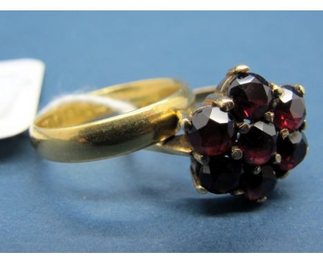 An 18ct Gold Plain Wedding Band, together with a garnet cluster ring, of flowerhead design, claw set. (2) 