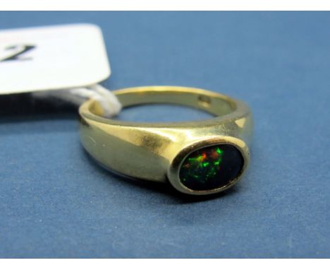 A Modern Black Opal Set Dress Ring, oval collet rubover set, stamped "18ct" "750". 