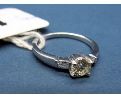 A Modern 18ct White Gold Single Stone Diamond Ring, four claw set to the centre, between baguette cut inset shoulders. 