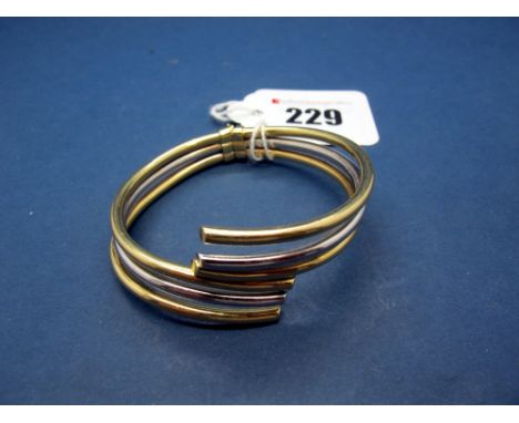 A Modern Bangle, of three row, two colour crossover hinged design, stamped "585". 