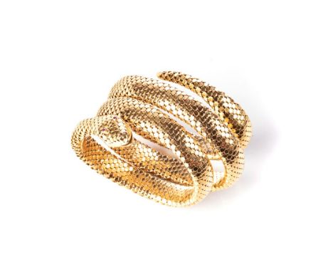 A GOLD SNAKE BANGLE Designed as a fexible stretch spiral, the eyes highlighted with circular mixed-cut rubies, impressed make