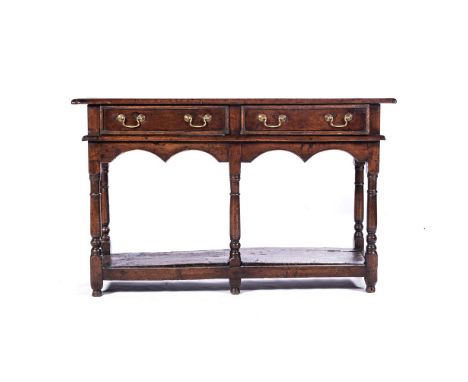 A GEORGE II OAK DRESSER The rectangular top above two short frieze drawers, beaded arched apron, on turned tapering supports,