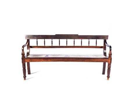 A CAPE STINKWOOD BENCH, LATE 19TH CENTURY The shaped top rail and plain mid-rail joined by turned spindles, curved arms on up