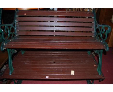 A suite of garden furniture, comprising; green painted cast iron ended and wood slatted three-seater bench, matching rectangu