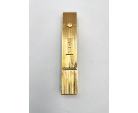 A 1940s Pery Watch Co. yellow metal (tests as 9ct) manual wind timepiece set within an engine turned linear design lipstick c