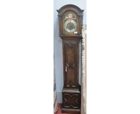 1930s Oak Grandmother Clock, with an arched hood, brass - silver dial, with Roman numerals, trunk door and base with applied 