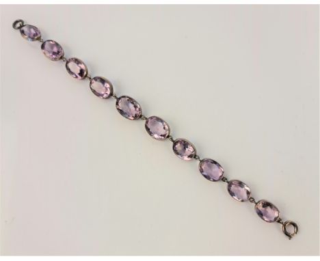 An amethyst line bracelet, set with ten oval cut amethysts, length approx. 20.5cm. IMPORTANT: Online viewing and bidding only