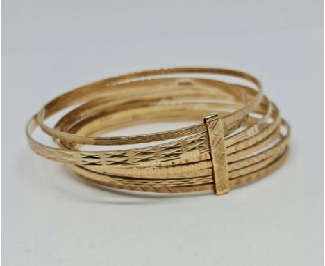 A hallmarked 9ct yellow gold multi-bangle bracelet, each bangle engraved with different geometric designs, diameter approx. 6