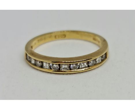 A hallmarked 18ct yellow gold diamond half eternity ring, set with eleven alternating round brilliant cut and square cut diam