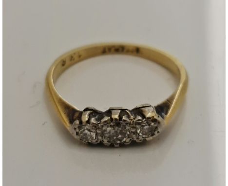 A three stone diamond ring, set with three graduated round brilliant cut diamonds (one A/F some damage), total diamond weight