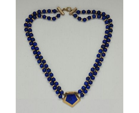A lapis lazuli bead necklace, featuring a central panel of lapis lazuli, stamped 375, length approx. 39cm. IMPORTANT: Online 