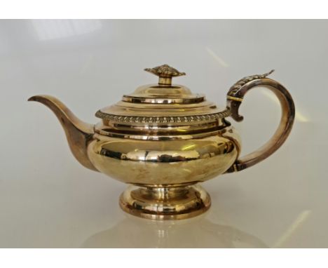 A George IV silver teapot, of squat form with reeded rim, foliage design to handle and finial, with ivory insulators, hallmar