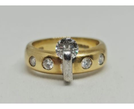 An 18ct yellow and white gold contemporary diamond ring, set with a principal round brilliant cut diamond measuring approx. 0