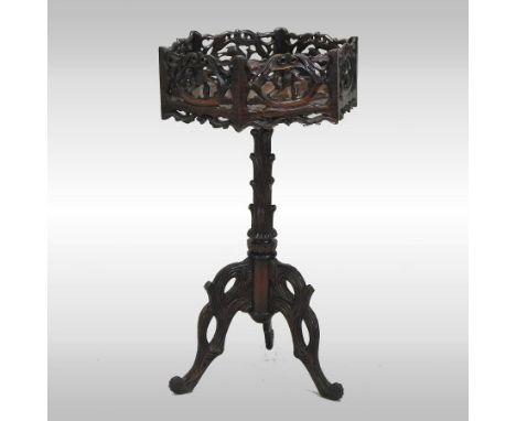 An ornate eastern carved hardwood jardiniere, with a pierced frieze, on a turned column and tripod base, 47cm