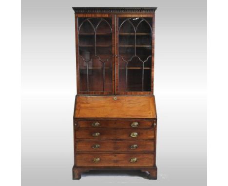 A George III mahogany glazed bureau bookcase, the dentil moulded cornice above a pair of astragal glazed doors, the fall encl