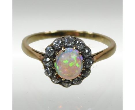 An 18 carat gold opal and diamond cluster ring, boxed