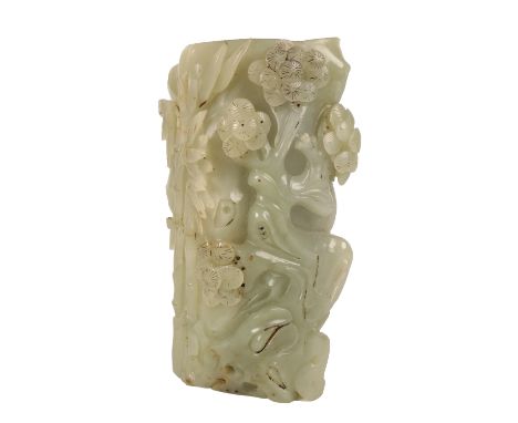CARVED CELADON JADE BRUSH POT, modelled as a tree trunk the sides naturalistically carved with leafy bamboo, pine and prunus,