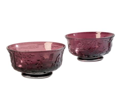 PAIR OF PEKING CARVED AMETHYST GLASS BOWLS, the sides decorated in relief with boys and pine trees, apocryphal Qianlong six c