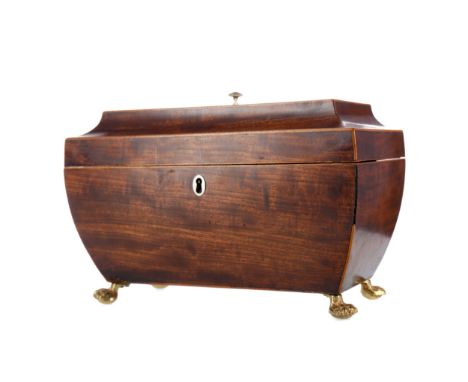 REGENCY MAHOGANY TEA CADDY, of sarcophagus form, boxwood strung, the hinged cover opening to lidded sections, on four paw fee