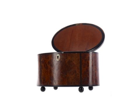 VICTORIAN BURR WALNUT CADDY, of oval form, with ebony stringing and mother of pearl escutcheon, the hinged cover opening to r