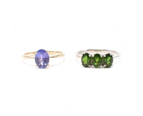 Two hallmarked 9ct gold stone set rings. The white gold ring set with three oval cut green diopside to pinched shoulders on a