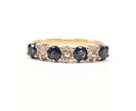 A vintage sapphire and diamond seven stone ring. The yellow metal ring set with a row of four round cut sapphires spaced by i