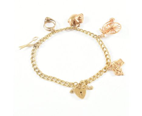 A vintage hallmarked 9ct yellow gold heart padlock bracelet with charms. The bracelet comprised of double curb links united b