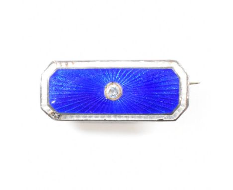 A Charles Horner sterling silver and guilloche enamel brooch pin. The pin set with a central blue stone surrounded by sunburs