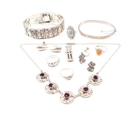 An assorted collection of silver and white metal jewellery. The lot to include a Mexican articulated pierced bangle bracelet 