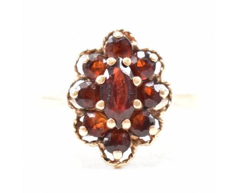 A vintage hallmarked 9ct yellow gold and garnet cluster ring. The ring having a marquise cut deep red garnet surrounded in a 