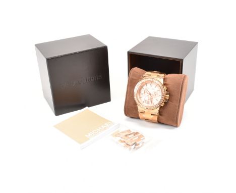 A Michael Kors stainless steel gold tone wrist watch. The watch having a circular rose gold tone dial with mixed baton and Ar