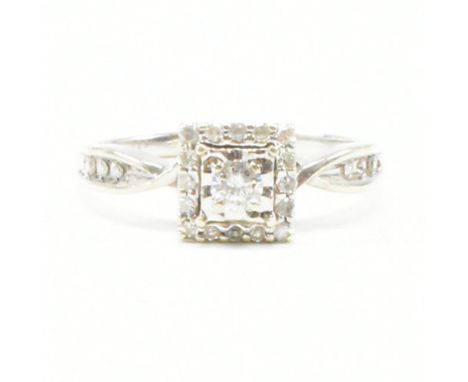 A vintage 9ct white gold and diamond cluster ring. The ring having a central round cut diamond surrounded by a square halo of