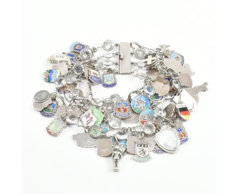 A vintage silver and white metal town charm bracelet. The bracelet strung with four strings of collet set paste stones and st