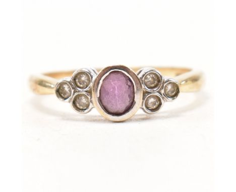 A hallmarked 9ct gold amethyst and diamond ring. The ring having a bezel set oval cut amethyst flanked by a trio of round cut